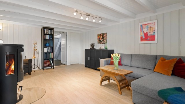 TV-stuen er av god størrelse, og har en koselig peis som gir både varme og hygge