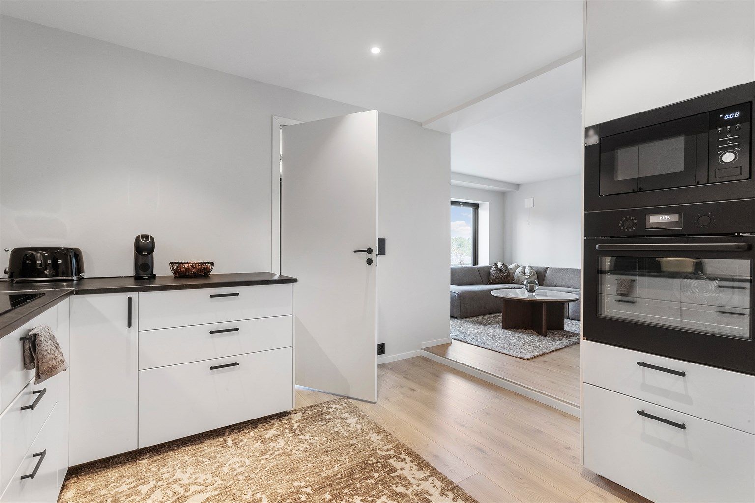 Fra kjøkkenet er det en åpen og naturlig overgang til en lys stue.