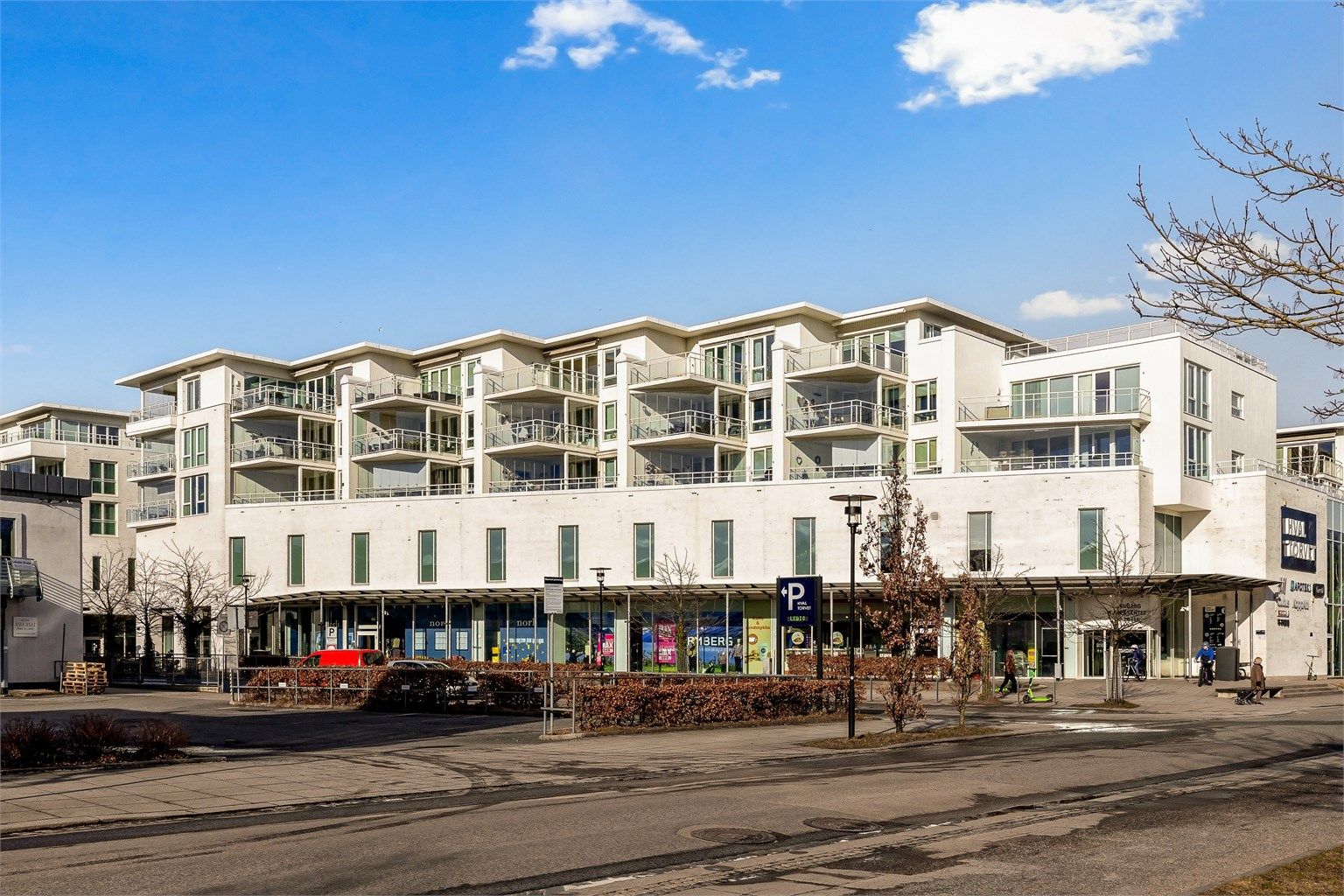 Bygget ligger vendt ut mot Torget, med butikker og servicetilbud i første etasje.