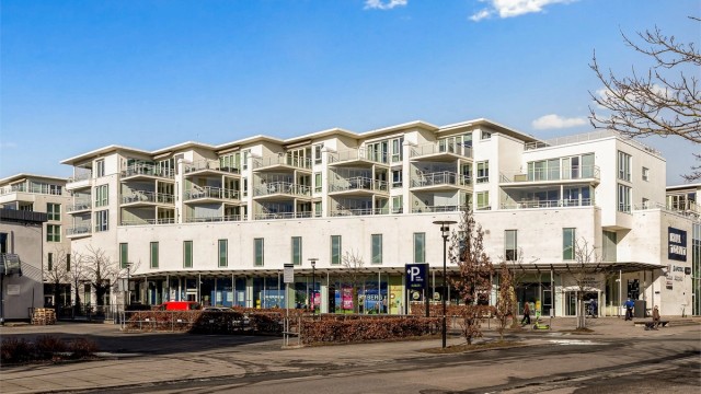 Bygget ligger vendt ut mot Torget, med butikker og servicetilbud i første etasje.