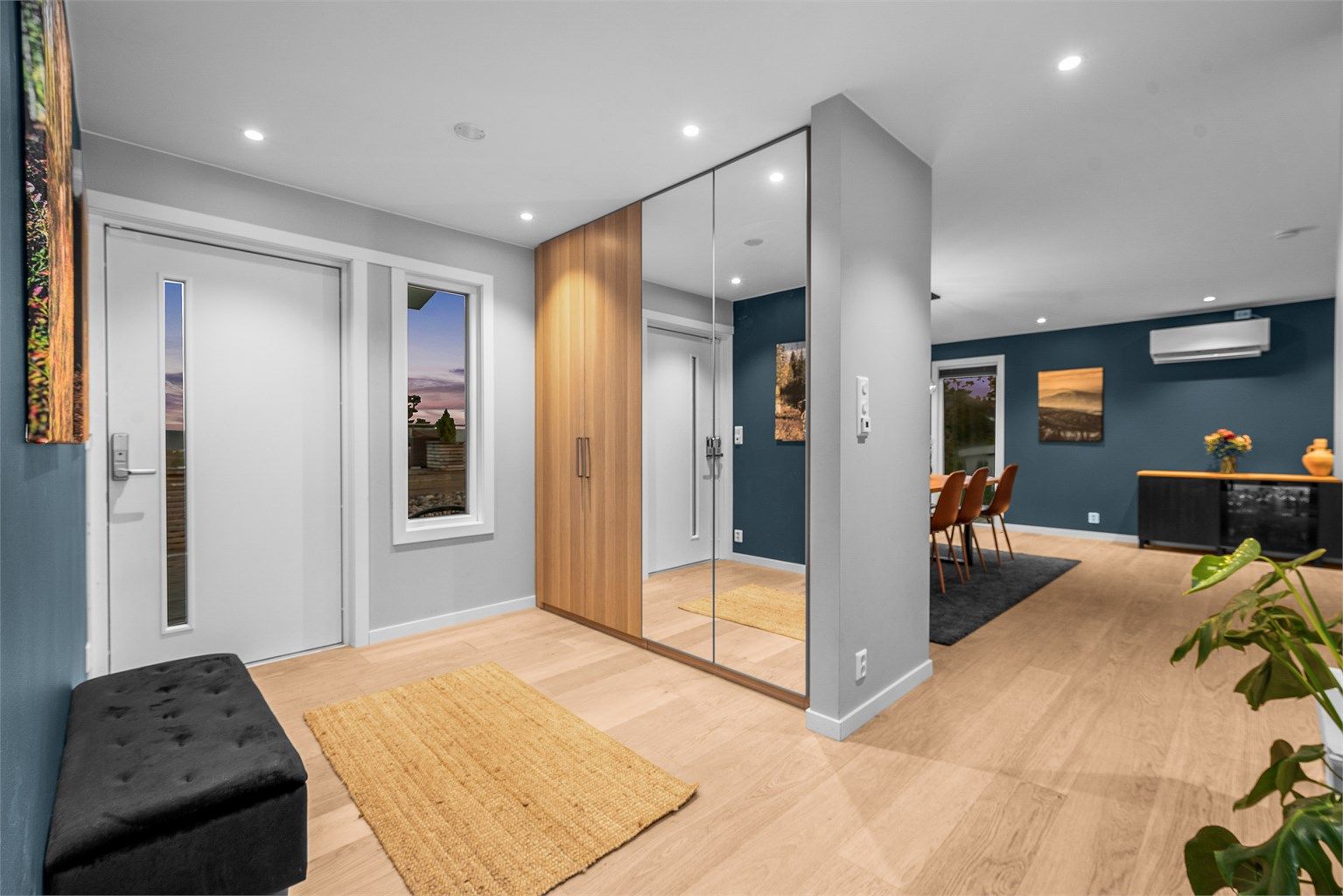 Selve entréen er av fin størrelse. Det er parkettgulv med gulvvarme, glatte malte veggflater og himling med downlights. Det er montert praktisk garderobeskap hvorav deler er med speilfronter. 