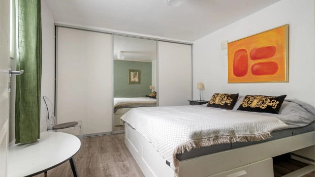 Romslig soverom med 1-stavs laminat fra 2017 på gulvet med gulvarme. Rommet har plass til dobbeltseng og stor skyvedørsgarderobe gir rikelig med garderobeplass