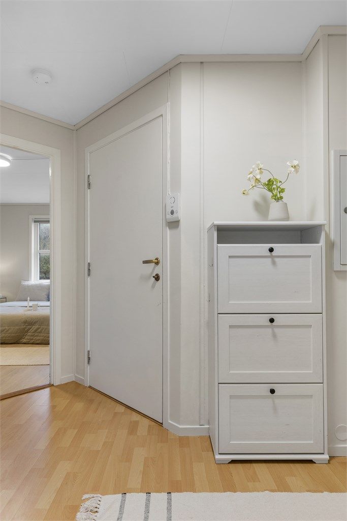 Lys og velkommen entré med plass til sko- og oppbevaringsmøbler. En praktisk inngangssone som gir et ryddig førsteinntrykk og god flyt videre inn i leiligheten.