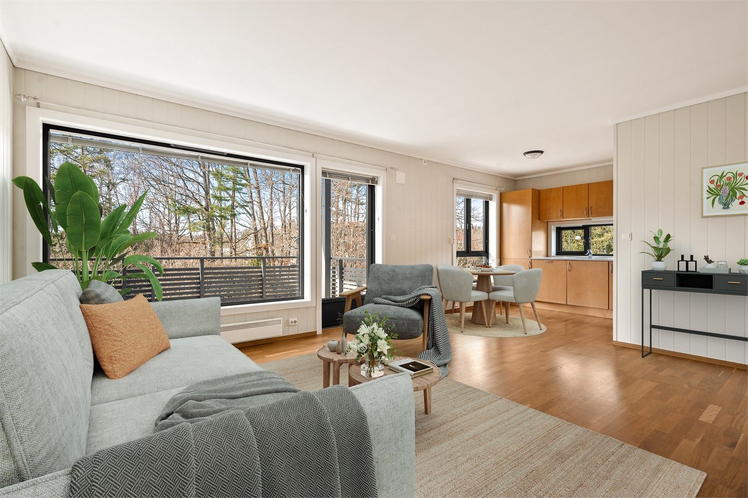 God plass for sofagruppe og spisebord i stue/kjøkkenavdelingen. Leiligheten ligger vendt med utsikt mot den omkringliggende naturen. (Digital møblering)