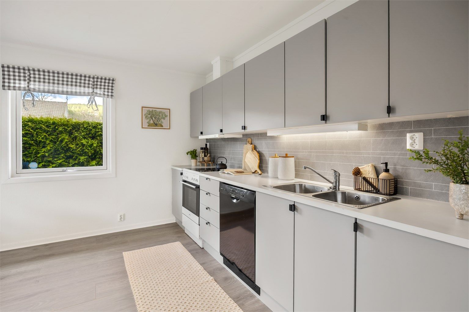 Kjøkkenet har en funksjonell utforming med skap- og benkeplass.