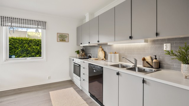 Kjøkkenet har en funksjonell utforming med skap- og benkeplass.