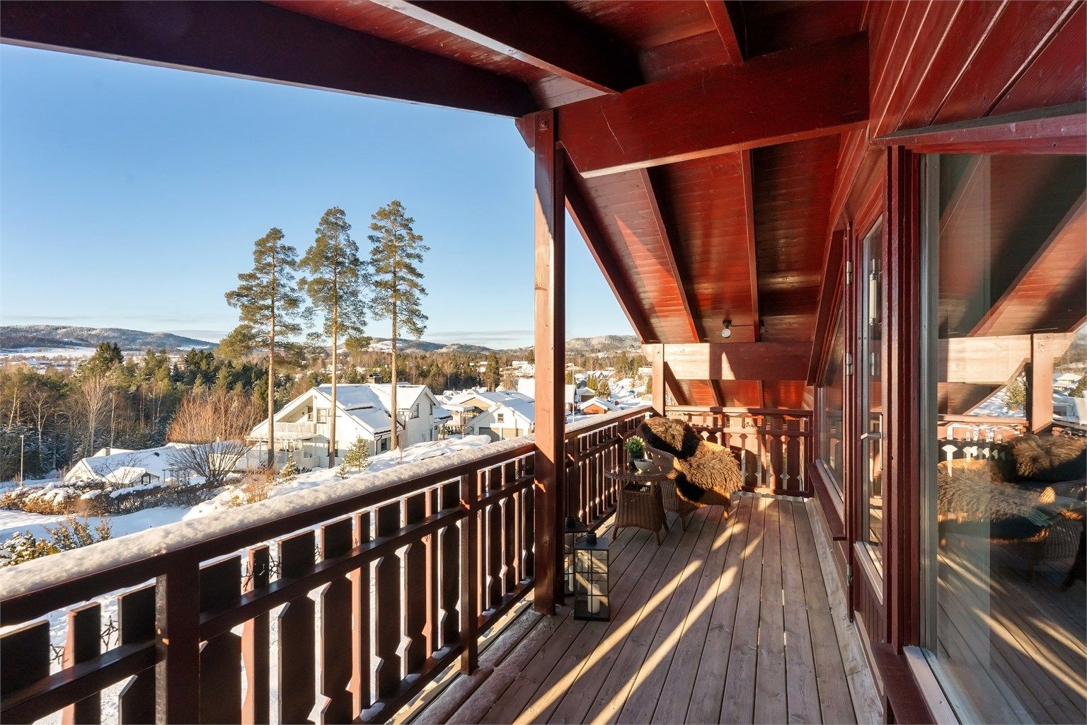 Balkongen har rekkverk og gulvflate av tre.