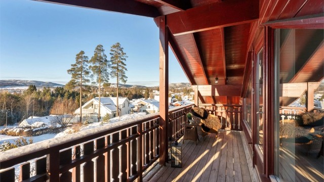 Balkongen har rekkverk og gulvflate av tre.