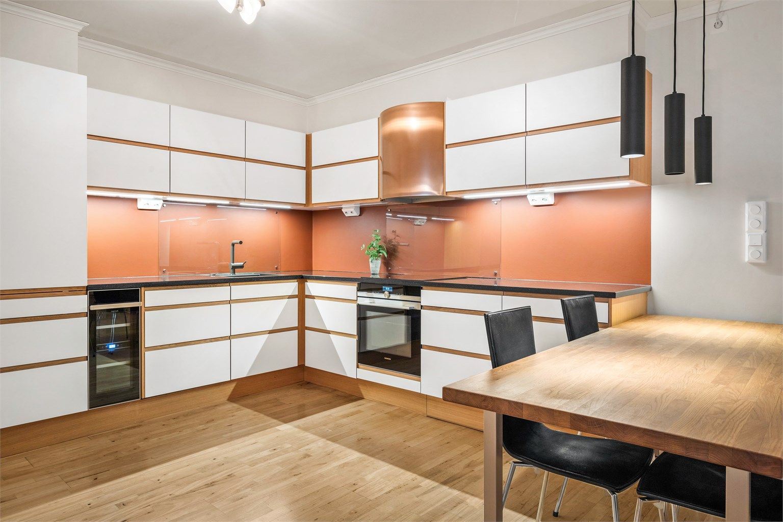 Lyst og innbydende kjøkken med glatte fronter og benkeplate i stein. Fotograf: Stine Prøitz Jørgensen. 