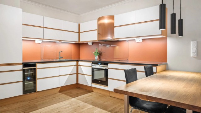 Lyst og innbydende kjøkken med glatte fronter og benkeplate i stein. Fotograf: Stine Prøitz Jørgensen.