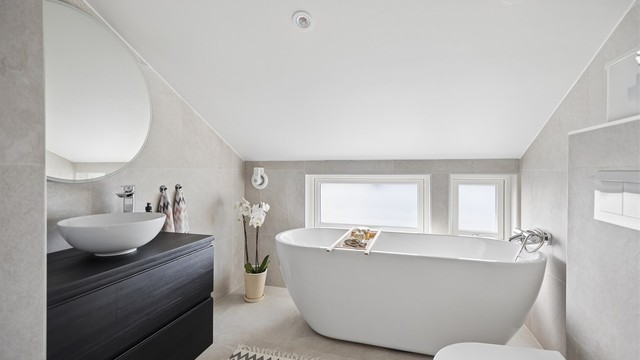 Lekkert, flislagt bad oppgradert i 2020. Badet fremstår som moderne og innbydende med badekar, dusjhjørne, servantinnredning og vegghengt toalett.