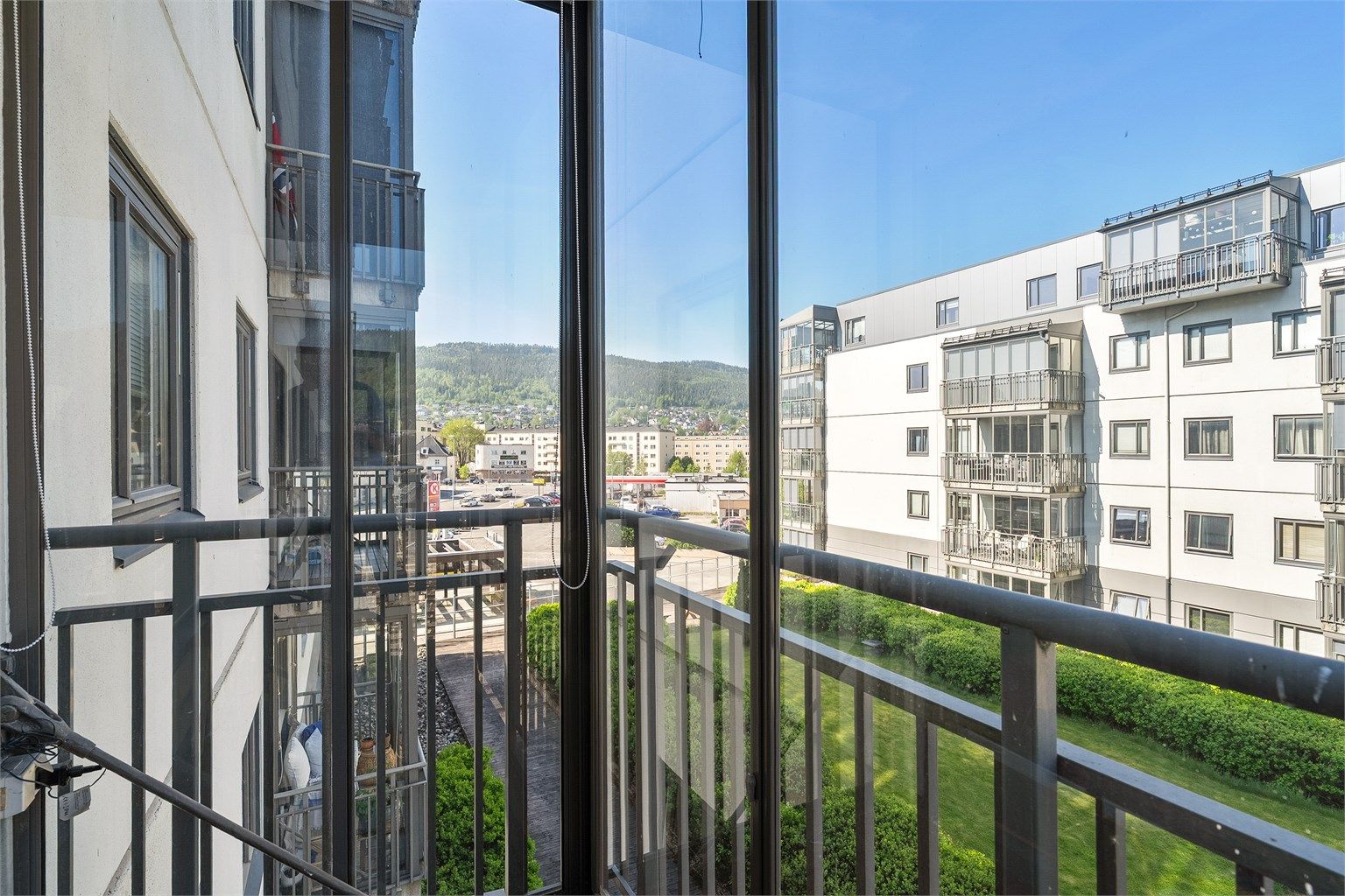 Fellesareal hevet over bakkeplan med plenarealer og beplantning