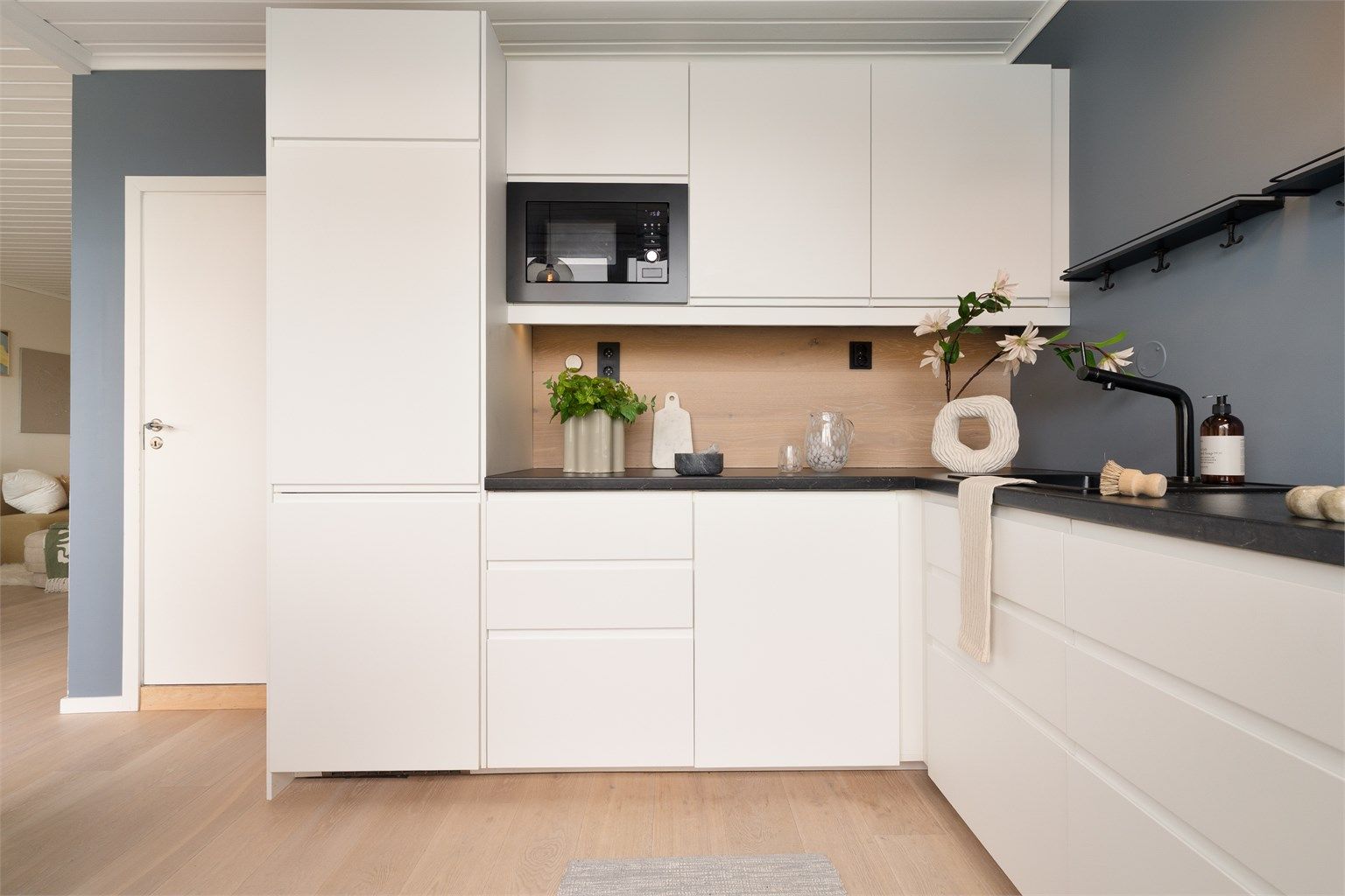 Kjøkkeninnredningen fra IKEA har slette fronter og integrerte hvitevarer.