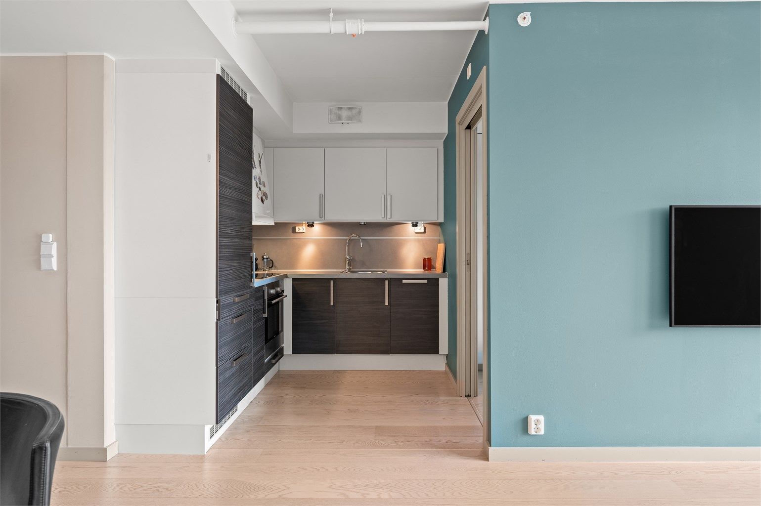 Kjøkkeninnredning fra HTH med glatte fronter. Alle hvitevarer som platetopp, stekeovn, oppvaskmaskin og kjøleskap er integrerte.