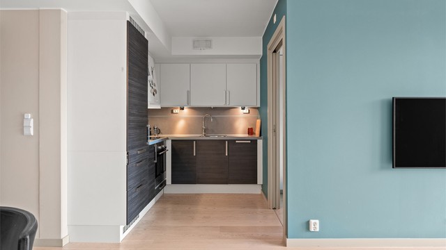 Kjøkkeninnredning fra HTH med glatte fronter. Alle hvitevarer som platetopp, stekeovn, oppvaskmaskin og kjøleskap er integrerte.