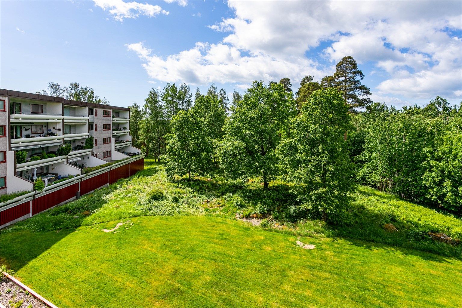Fra leilighetens intime balkong kan du skue ut over store grøntarealer på borettslagets eget område.