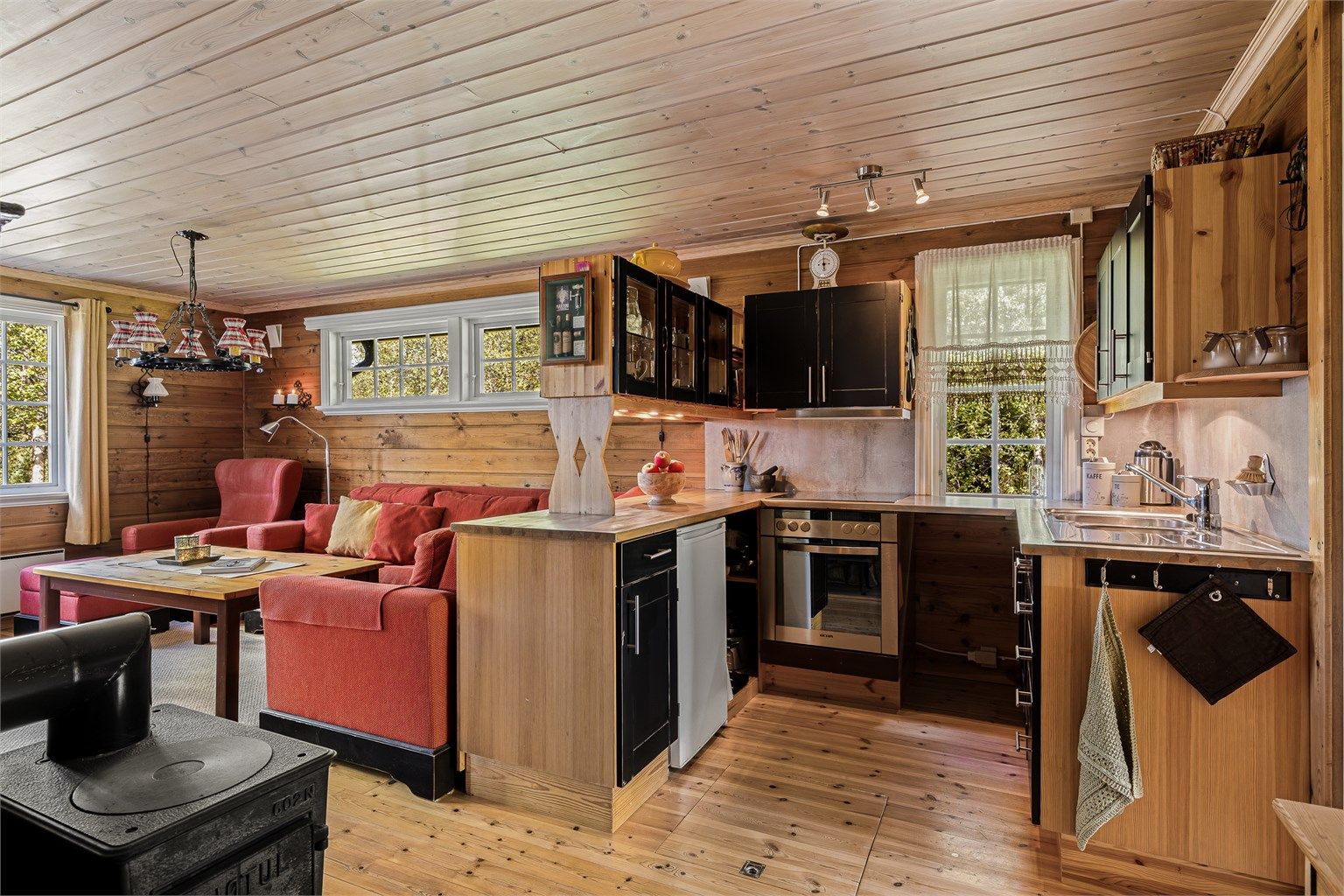 Kjøkkeninnredning med profilerte fronter og benkeplate av tre med nedfelt oppvaskkum.