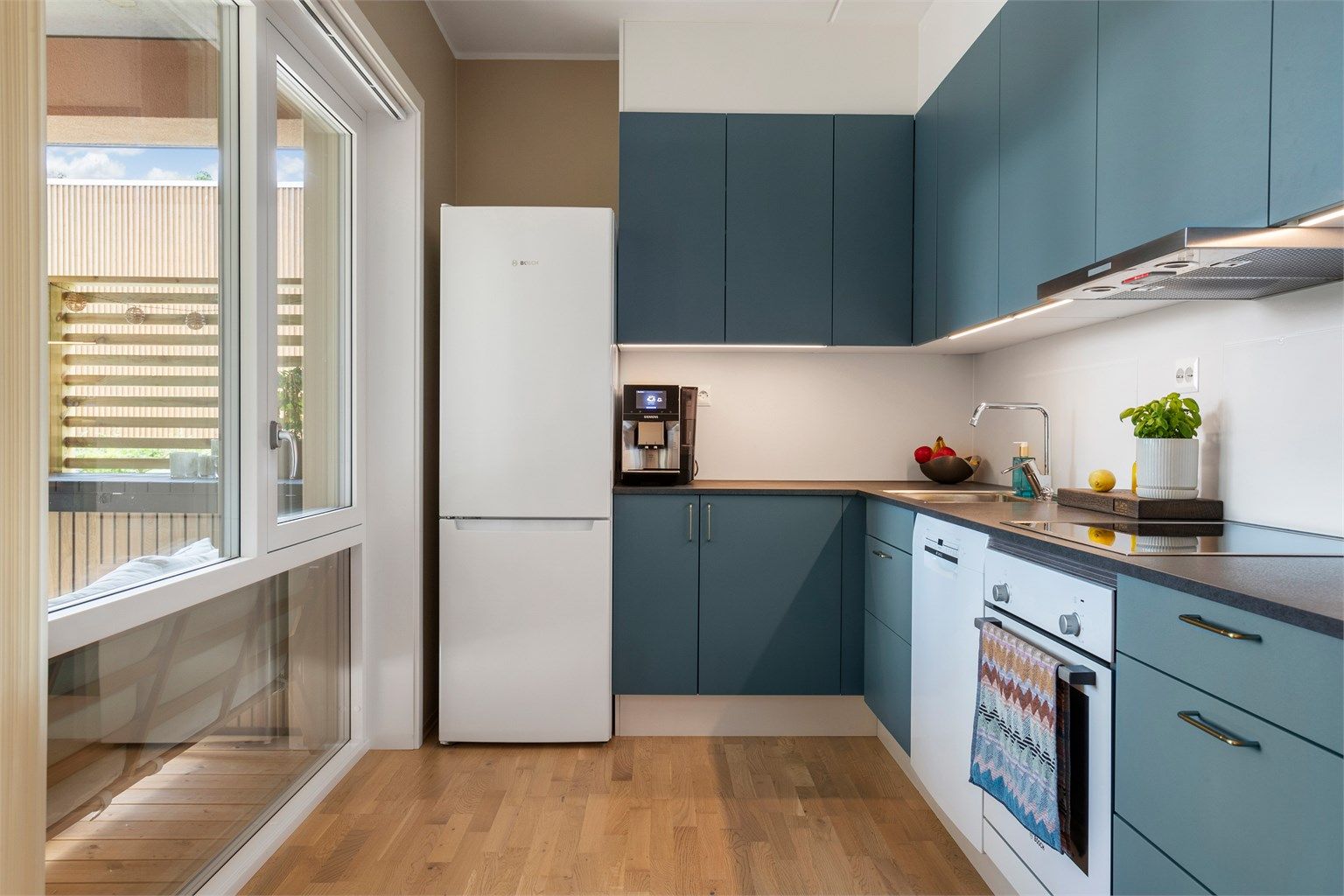 Kjøkkeninnredning fra HTH med glatte fronter og laminat benkeplate. Vannbåren gulvvarme. 
