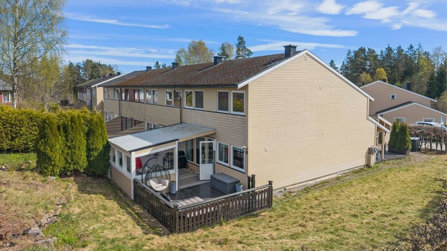 Boligen har en hyggelig hage med hekk og gressplen.