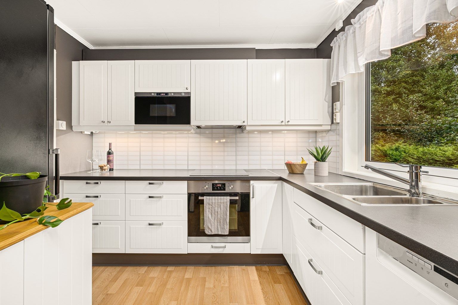 Lyst og innbydende kjøkken som har godt med både benk og skapplass