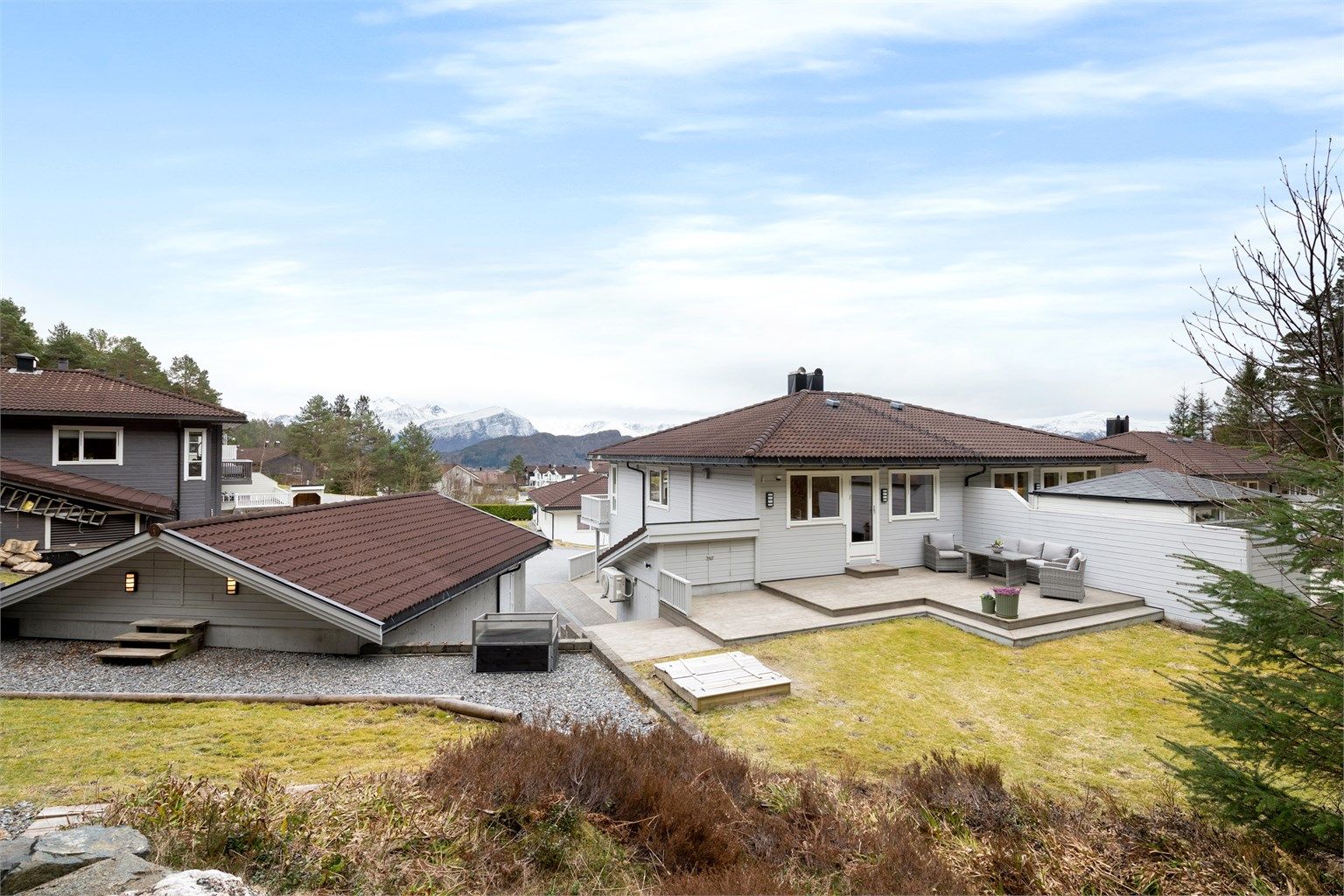 Eiendommen har en skjermet og solrik beliggenhet, med stor terrasse og skjermet hage.