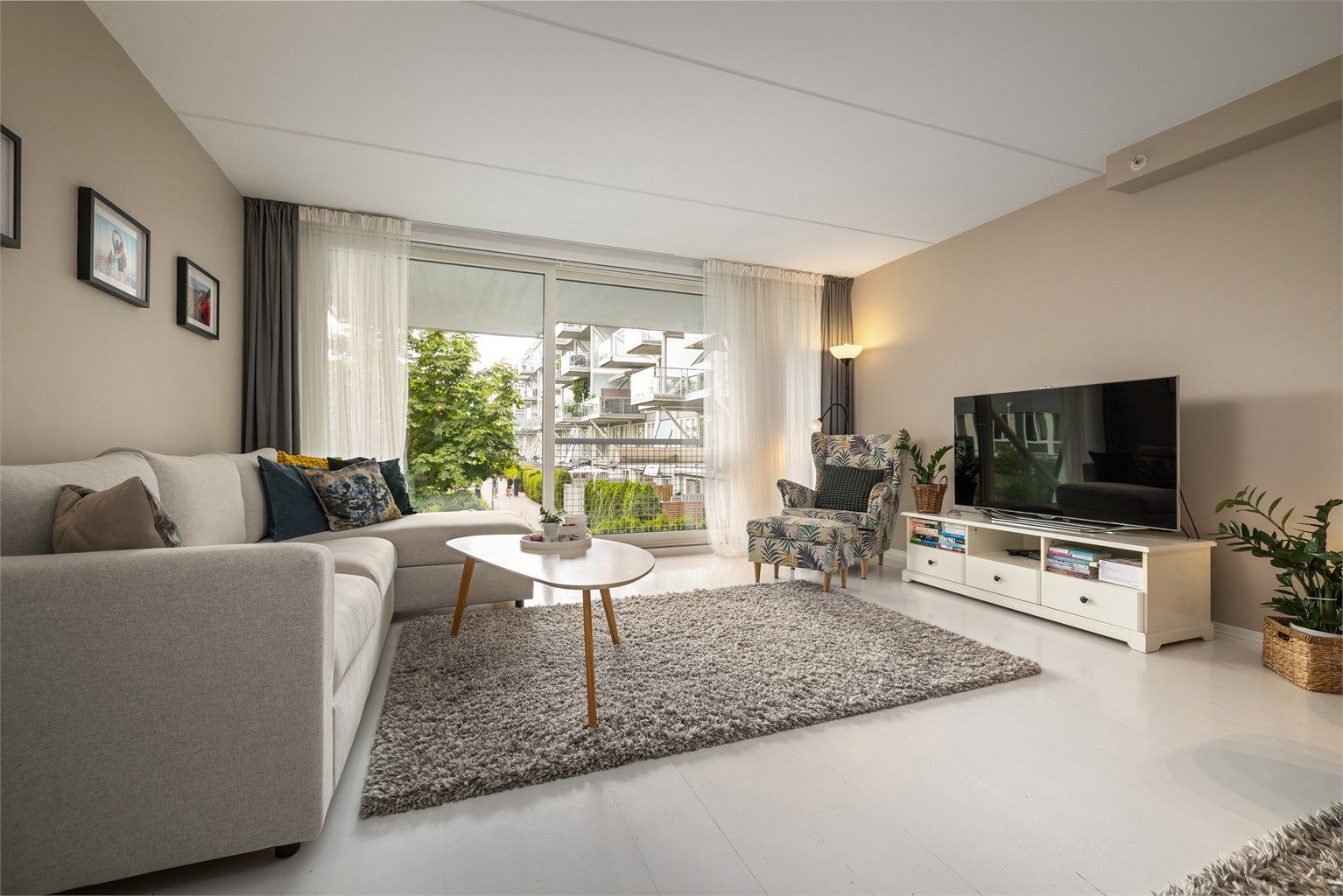 Lys stue med store vindusflater fra gulv til tak som gir godt innslipp av naturlig lys.