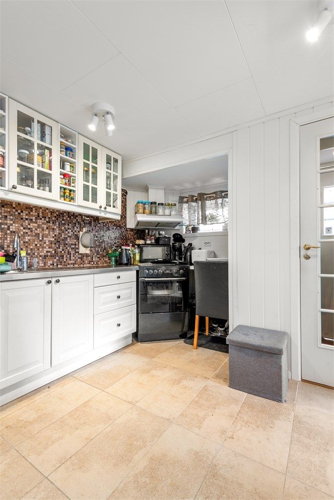 Praktisk kjøkken i underetasjen med Ikea-innredning, flislagt gulv og varmekabler. Bruksendringen er ikke omsøkt.