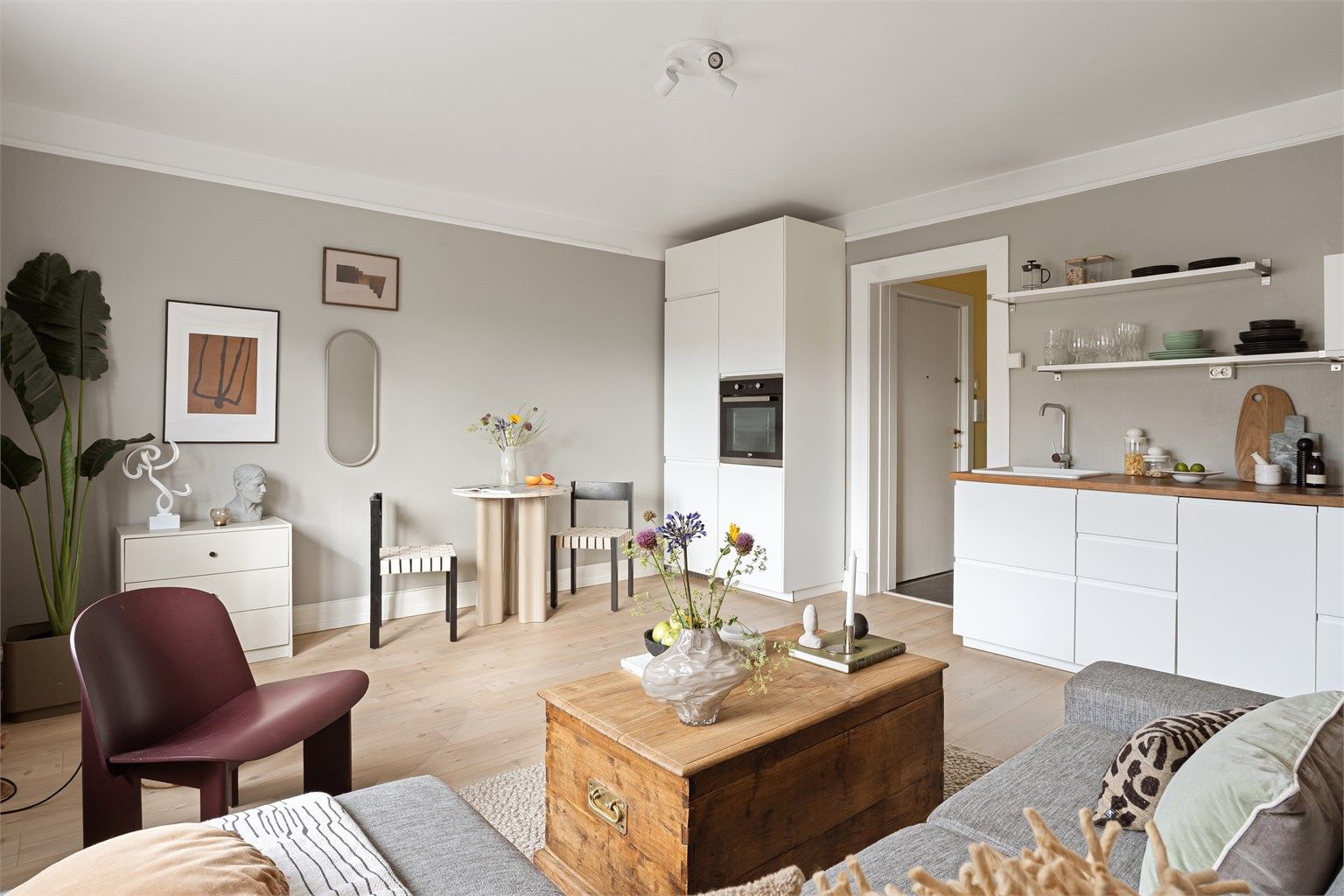 Et lekkert kjøkken er sentralt plassert i stuen. Det kombinerer tidløs design med integrerte hvitevarer og god oppbevaringsplass.