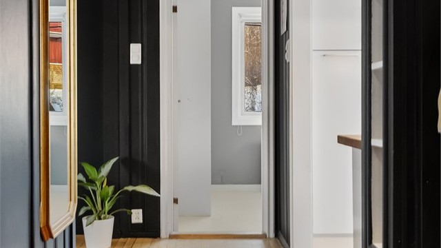 Gangen leder videre inn mot kjøkkenet og leilighetens sosiale soner.