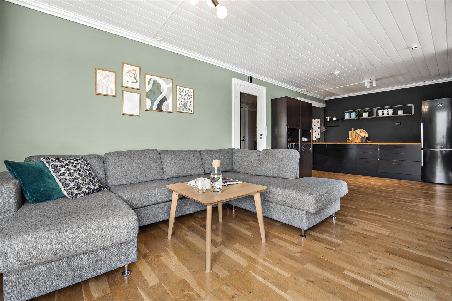 Praktisk stue i tilknytning til kjøkkenet med plass til stor sofagruppe.