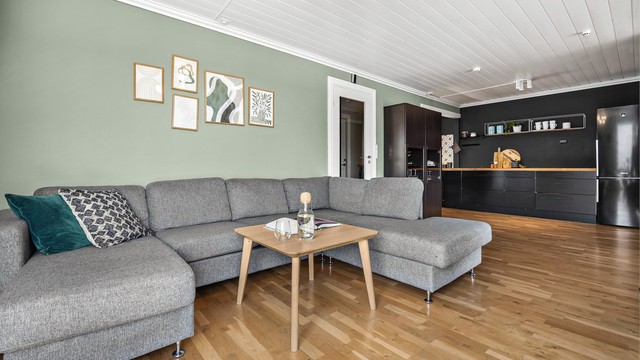 Praktisk stue i tilknytning til kjøkkenet med plass til stor sofagruppe.