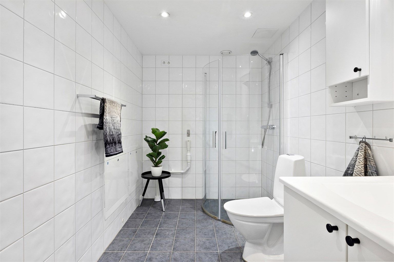 Badet har opplegg for vaskemaskin og dusjhjørne med svingdører. 