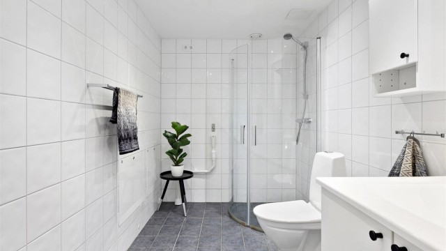 Badet har opplegg for vaskemaskin og dusjhjørne med svingdører.