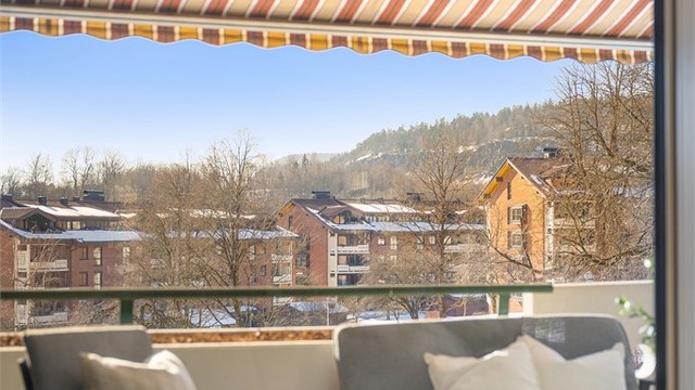 Balkongen har en åpen og luftig plassering med utsikt over fellesområdene.