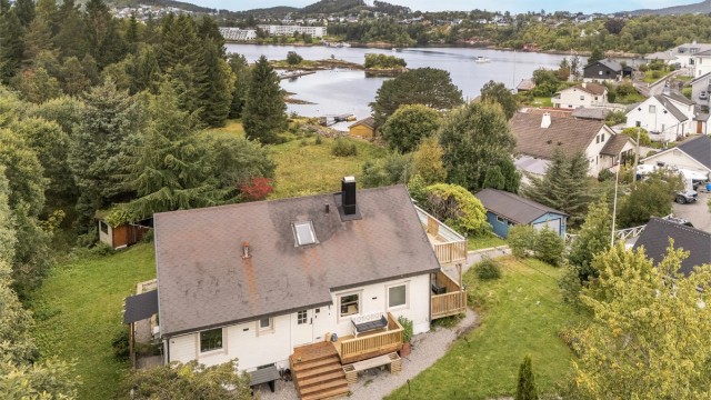 Eiendommen har en åpen beliggenhet med utsyn mot sjøen og det omkringliggende kystlandskapet.