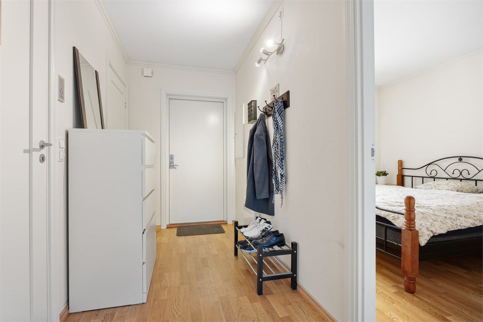 Praktisk entré med parkettgulv og plass til oppbevaring av yttertøy.