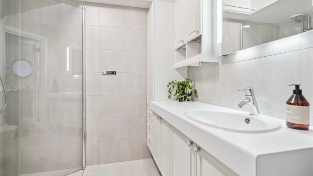 Pent flislagt bad med adkomst fra gangen. Her finner du servantinnredning, vegghengt toalett og dusjhjørne med innfellbare glassdører.