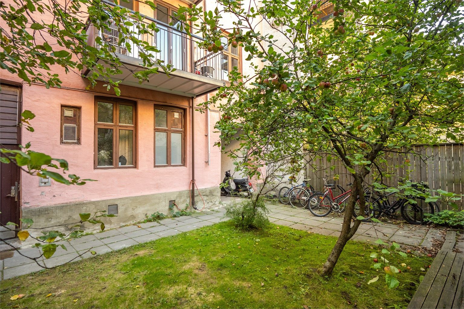 Leiligheten ligger tilbaketrukket mot en grønn og frodig bakgård, skjermet fra byens puls.