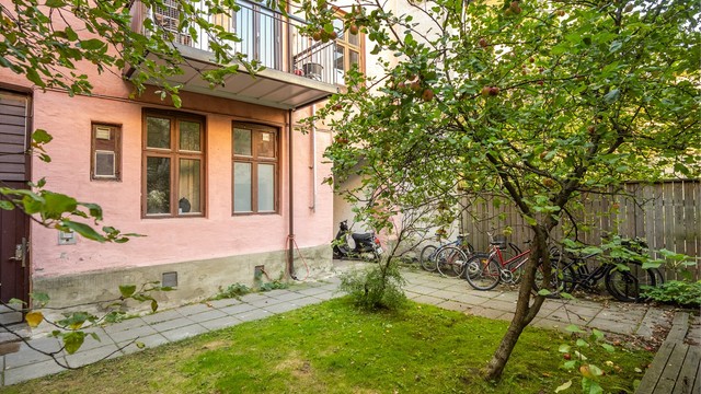 Leiligheten ligger tilbaketrukket mot en grønn og frodig bakgård, skjermet fra byens puls.