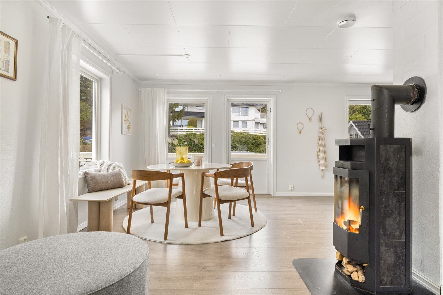 Spisestuen er plassert mellom stuen og kjøkkenet, med en vedovn som gir ekstra varme og hygge.