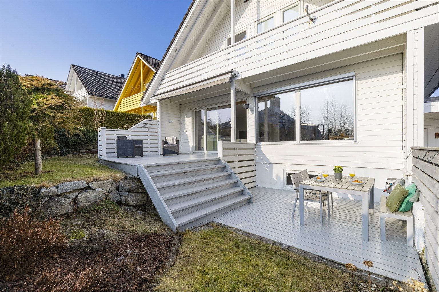 Tomten er pent opparbeidet med plen og terrasser på flere nivåer.