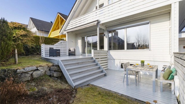 Tomten er pent opparbeidet med plen og terrasser på flere nivåer.