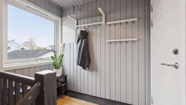 Entré og trapperom med malt panel og plass til yttertøy.(Fellesgang)