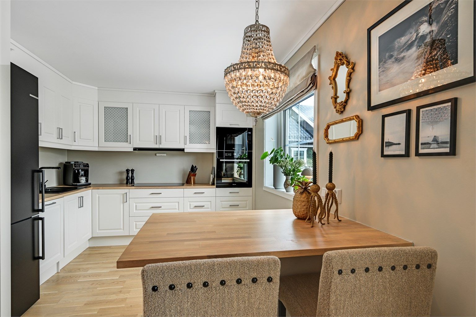 Kjøkkenet fremstår som stilrent og funksjonelt med innredning i profilerte fronter og benkeplate i heltre eik.