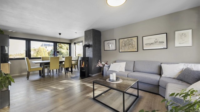 Boligen har en lys stue i hovedetasjen med peisovn og god plass til både sittegruppe og spisebord.
Foto: Hallvard Rimereit