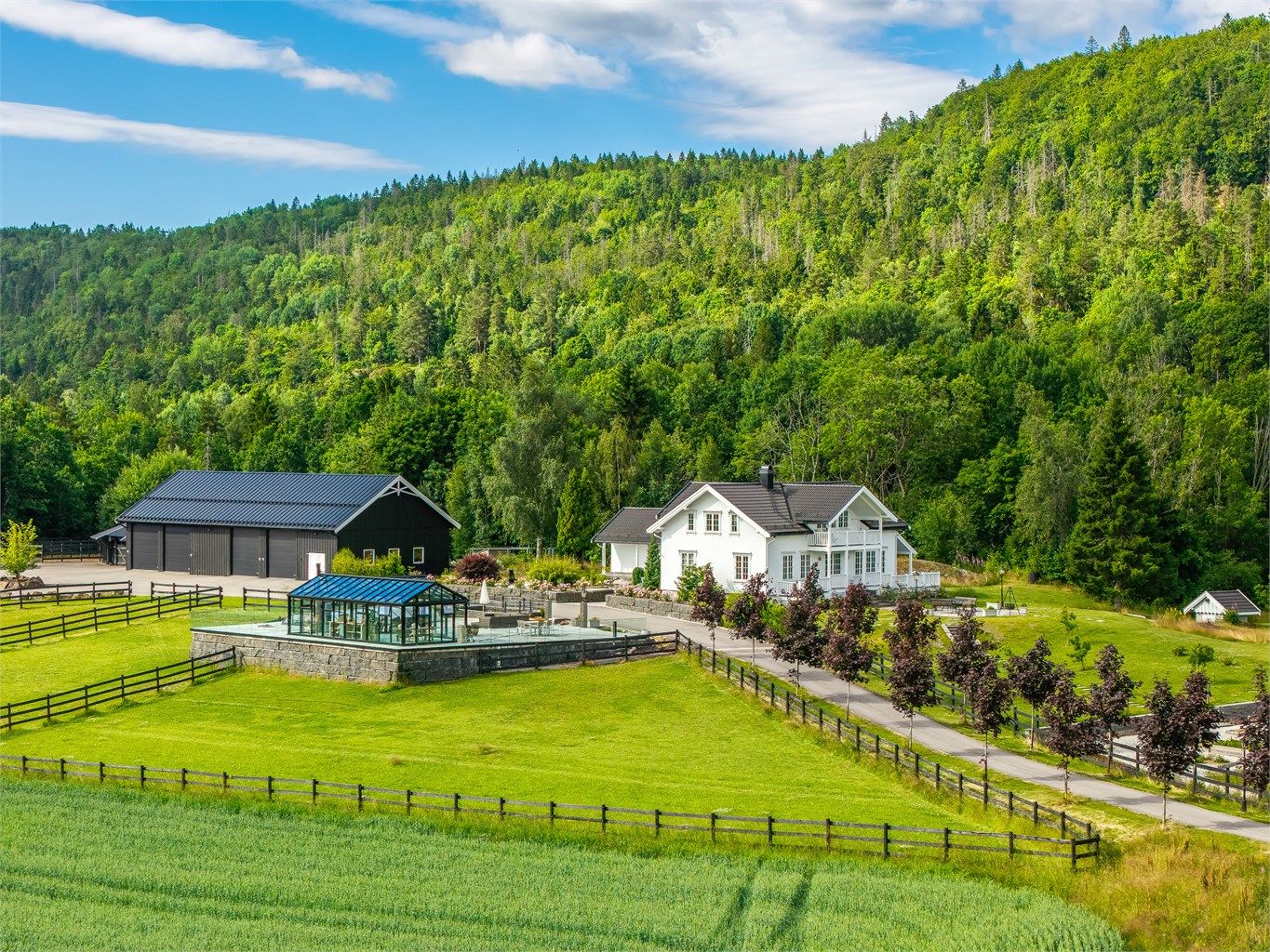  Tunet fremstår innbydende og solrikt, med en romslig og skjermet hage beplantet med frukttrær, grønne plenarealer og naturlig vegetasjon som understreker eiendommens landlige og sjarmerende karakter.