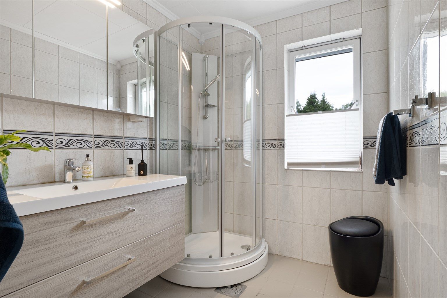 Det er bad både i 1. etasje og kjelleren. Badet i hovedetasjen har flislagt gulv med gulvvarme, flislagte vegger, servantinnredning og dusjkabinett.