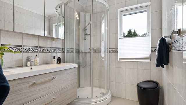 Det er bad både i 1. etasje og kjelleren. Badet i hovedetasjen har flislagt gulv med gulvvarme, flislagte vegger, servantinnredning og dusjkabinett.