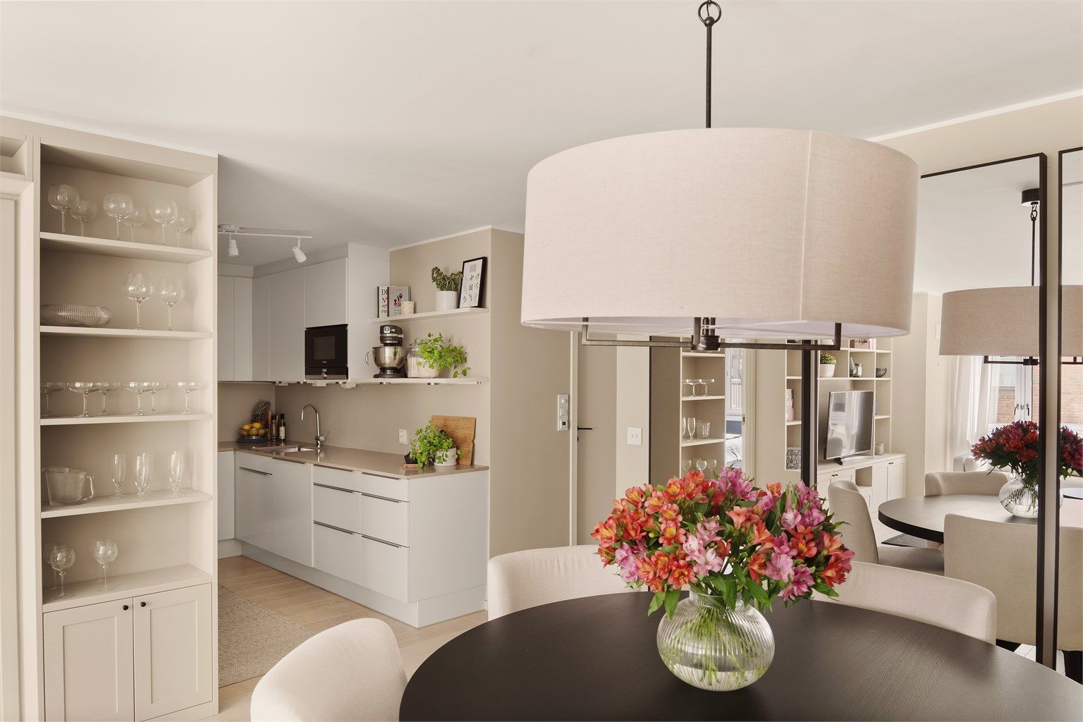 Romslig stue i delvis åpen løsning med kjøkkenet.