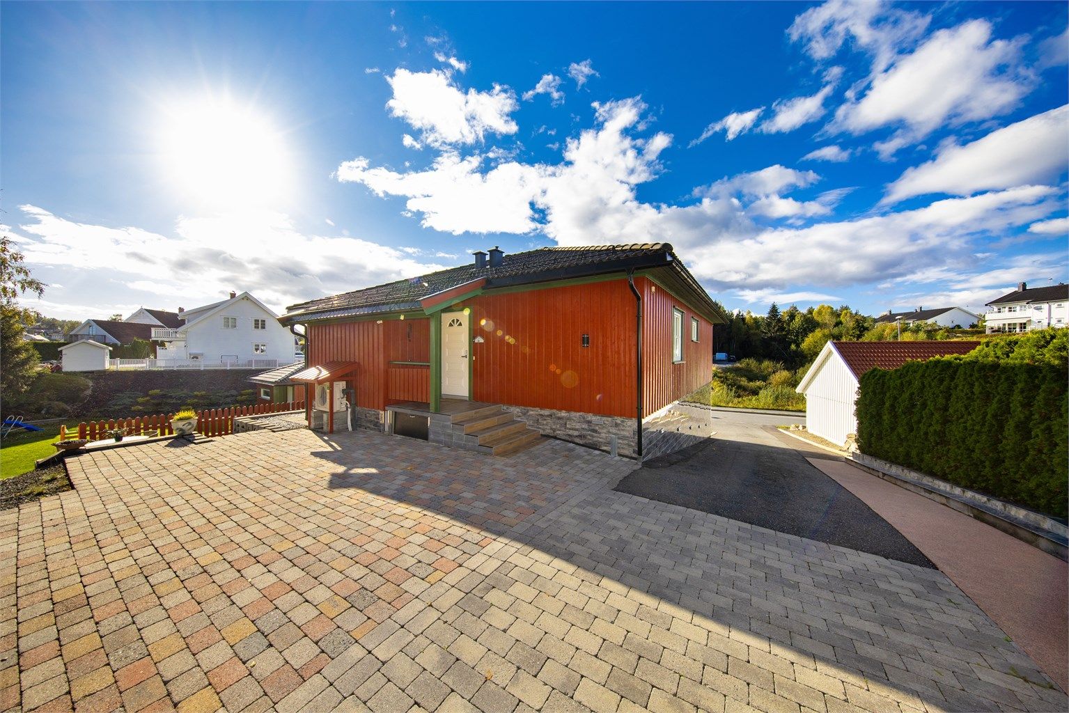 Gårdsplass ved inngangsparti på øvre plan har belegningsstein.